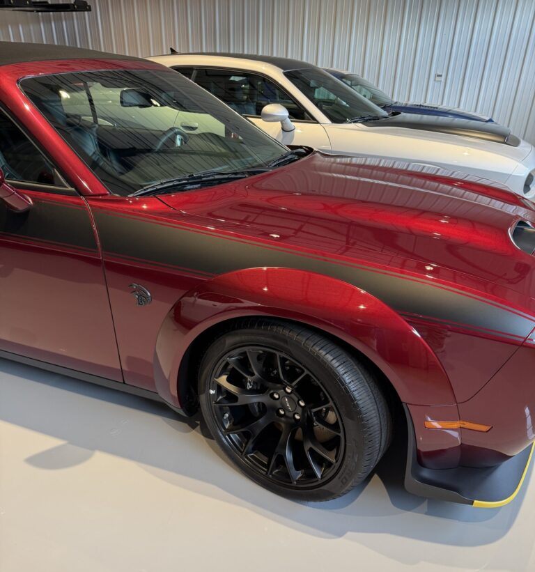 A close-up view of a shiny car hood reflecting the surroundings, showcasing a detailed car detailing service.
