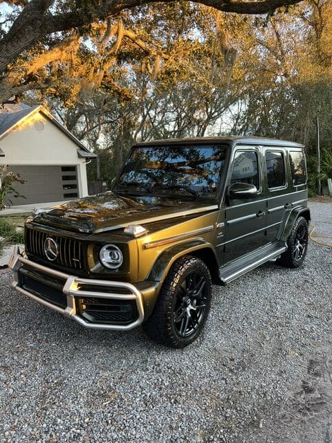 A shiny, detailed close-up of a car's polished surface reflecting light, showcasing Moran's Performance Detailing expertise.