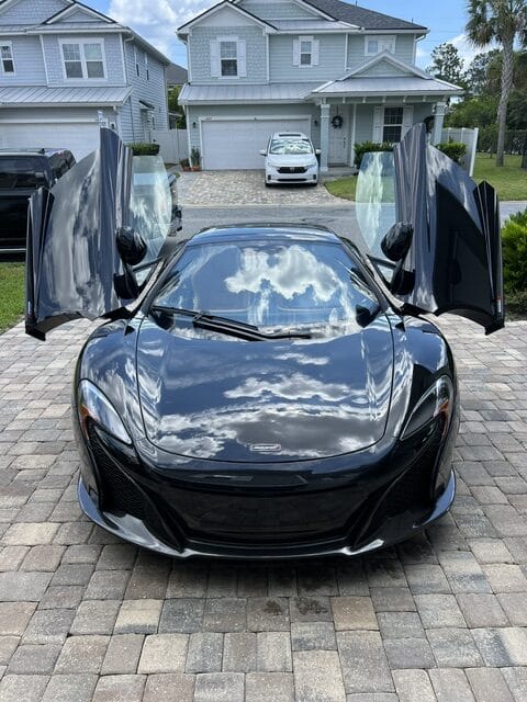A close-up of a shiny car hood reflecting light, showcasing the high-quality detailing from Moran's Performance Detailing.
