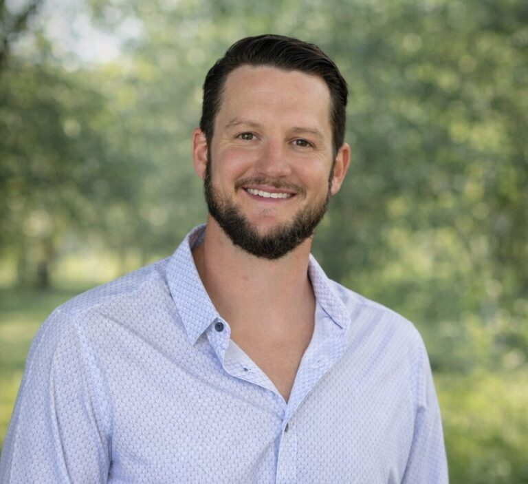 Moran Michael, an expert in premium detailing Jacksonville FL, stands confidently in a detailing shop surrounded by tools.