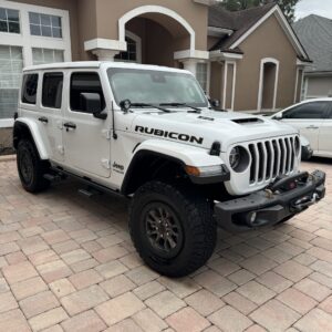 A close-up of a shiny, well-polished car surface reflecting light, showcasing the detailing work at Moran's Performance Detai