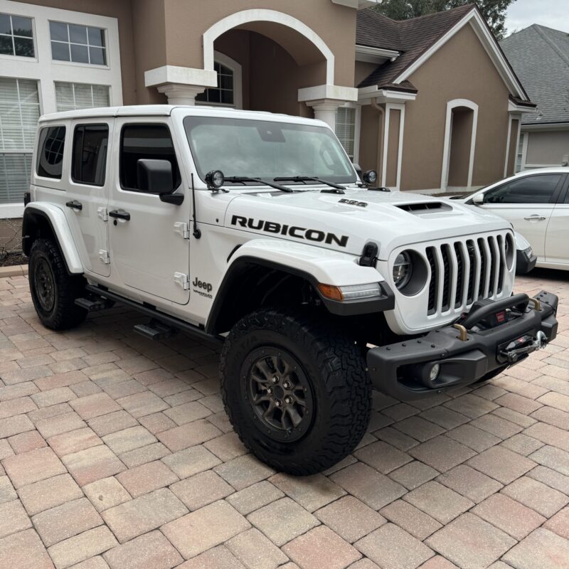 A close-up of a shiny, well-polished car surface reflecting light, showcasing the detailing work at Moran's Performance Detai