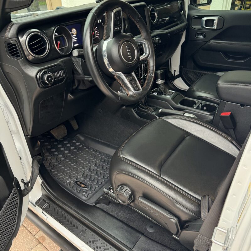 A detailed view of a polished car hood reflecting the surrounding environment, showcasing the shine and clarity of the finish