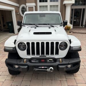 A close-up view of a polished car hood reflecting light, showcasing the shine and detail of the surface.