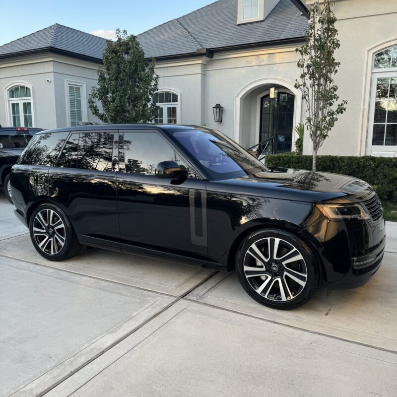 A close-up of a shiny, detailed car hood reflecting light, showcasing a professional detailing job.