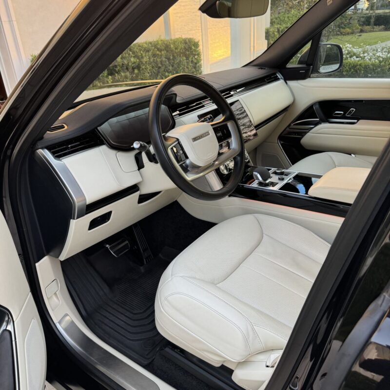 A close-up view of a polished car surface reflecting light, showcasing the shine and clarity of the detailing work.