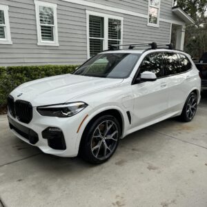 A detailed view of a shiny black car exterior, showcasing a flawless finish and reflections, emphasizing quality detailing.