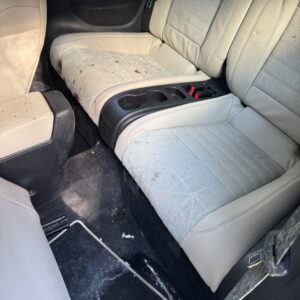 A close-up view of a shiny car hood reflecting light, showcasing its polished surface and detailing work.