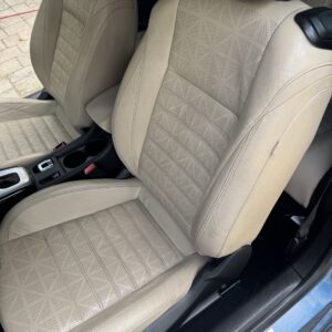 A detailed view of a shiny car exterior, showcasing its polished surface and reflections, emphasizing vehicle detailing.