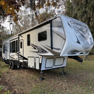 A close-up of a shiny black car hood reflecting natural light, showcasing its polished surface and detailing.