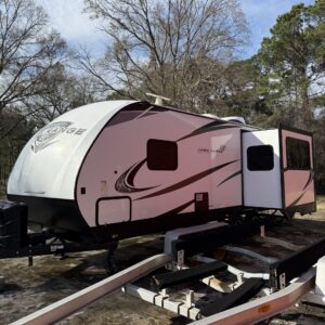 A detailed close-up of a shiny black car hood reflecting light, showcasing a pristine finish and meticulous detailing.