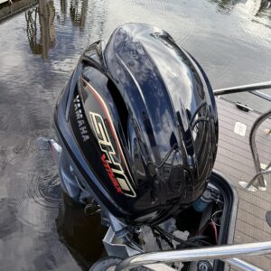 A detailed view of a shiny black car hood reflecting light, showcasing the quality of Moran's Performance Detailing.