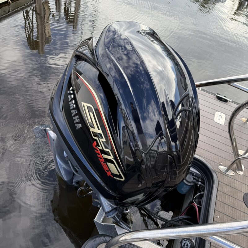 A detailed view of a shiny black car hood reflecting light, showcasing the quality of Moran's Performance Detailing.