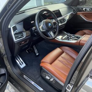 A close-up of a shiny, well-polished car hood reflecting light, showcasing the detailing work done.