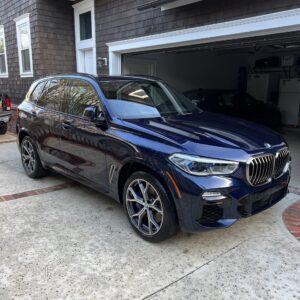 A detailed view of a shiny car hood reflecting light, showcasing the quality of Moran's Performance Detailing services.