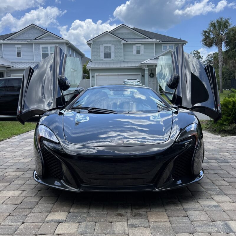 A detailed view of a car's shiny surface reflecting light, showcasing the quality of Moran's Performance Detailing services.