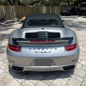 A detailed view of a shiny, well-polished car hood reflecting the surroundings, showcasing excellent detailing work.