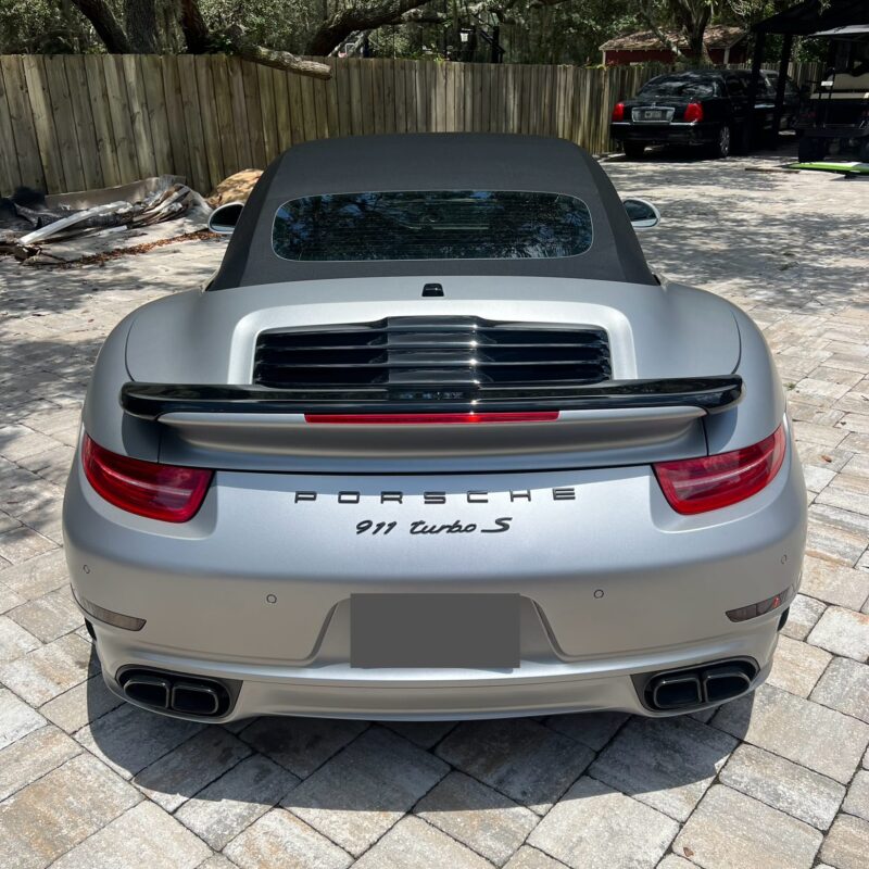 A detailed view of a shiny, well-polished car hood reflecting the surroundings, showcasing excellent detailing work.